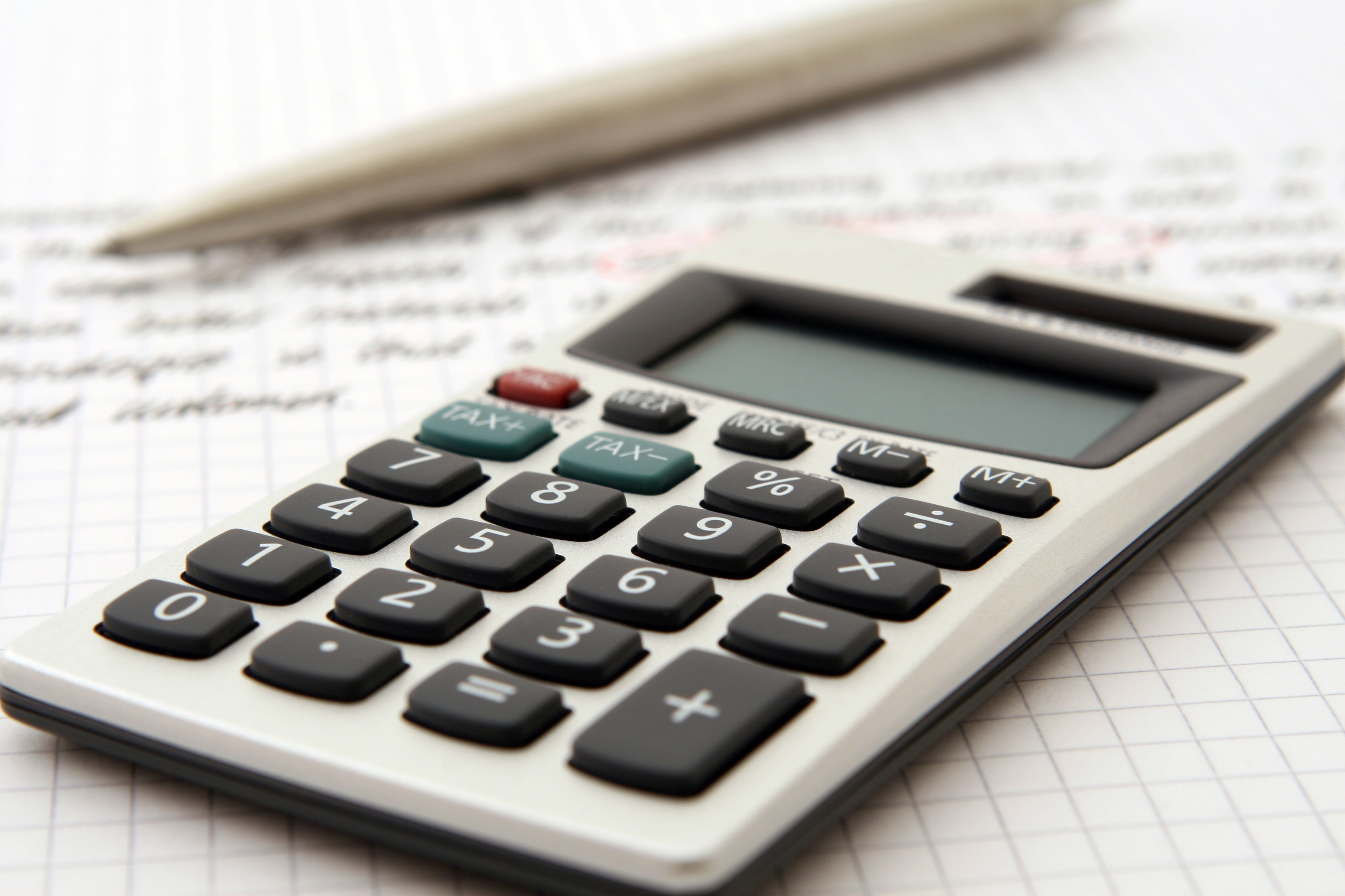 Calculator and financial documents on a desk for accounting.